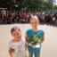 im Vordergrund: zwei Mädchen mit Urkunde und Blumen, im Hintergrund Kinder der Leonardoschule