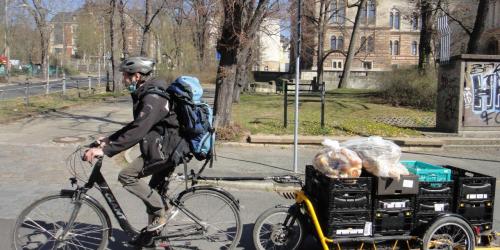 Ein Fahrradfahrer transportiert Lebensmittel mit einem Fahrradanhänger