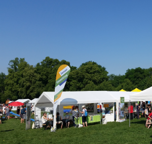 Pavillons und Menschen auf einer Wiese, Flagge mit Aufschrift "Jenaer Umwelttag"