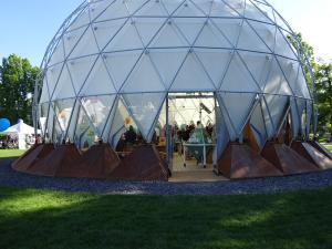 Blick auf die weiße Kuppel und Eingang des Klimapavillons