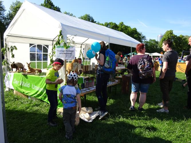 Weißer Pavillon mit ausgestopften Waldtieren, im Vordergrund Kinder und Erwachsene