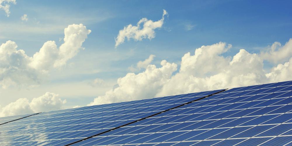 Photovoltaikanlage vor blauem Himmel mit weißen Wolken