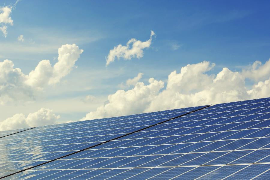 Photovoltaikanlage vor blauem Himmel mit weißen Wolken
