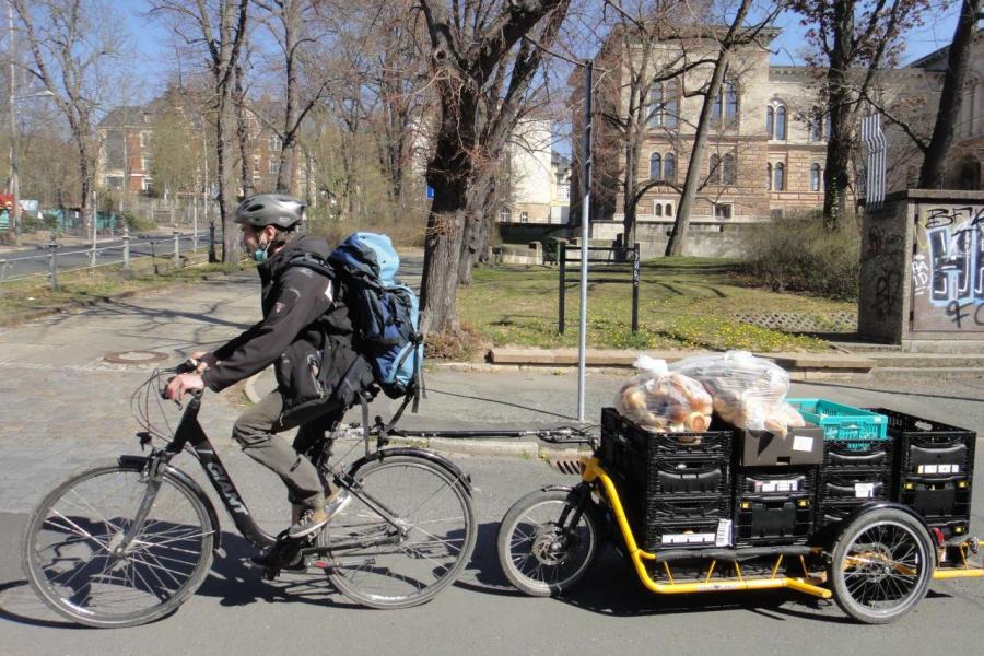 Ein Fahrradfahrer transportiert Lebensmittel mit einem Fahrradanhänger